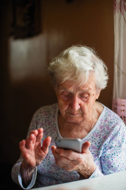 istock Elderly woman sits with a smartphone in her hands. 1097653450