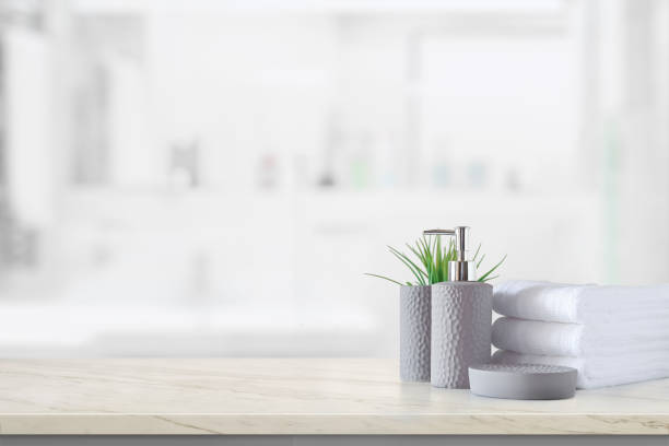 istock Ceramic shampoo bottle with white cotton towels on marble counter over bathroom background 1097656392