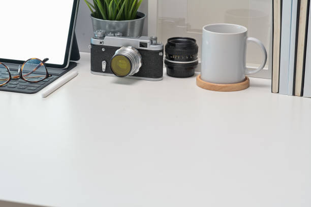 istock Stylish workplace desk vintage camera, blank screen tablet and gadget 1097656524