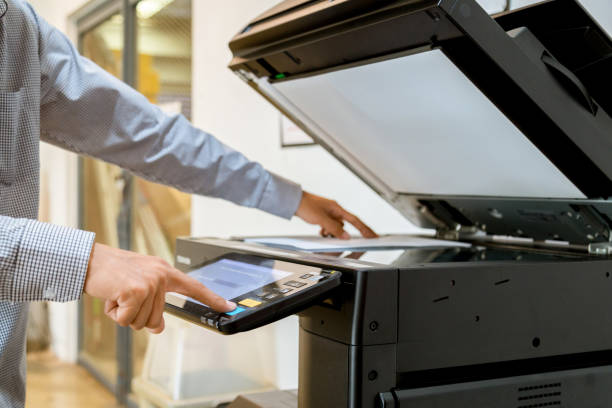 istock Business man Hand press button on panel of printer, printer scanner laser office copy machine supplies start 1097677012