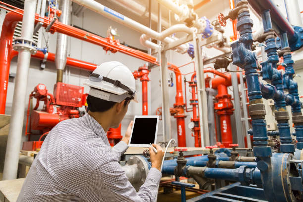 istock Engineer with tablet check red generator pump for water sprinkler piping and fire alarm control system. 1097682804