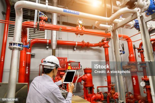 Engineer With Tablet Check Red Generator Pump For Water Sprinkler Piping And Fire Alarm Control System Stock Photo - Download Image Now