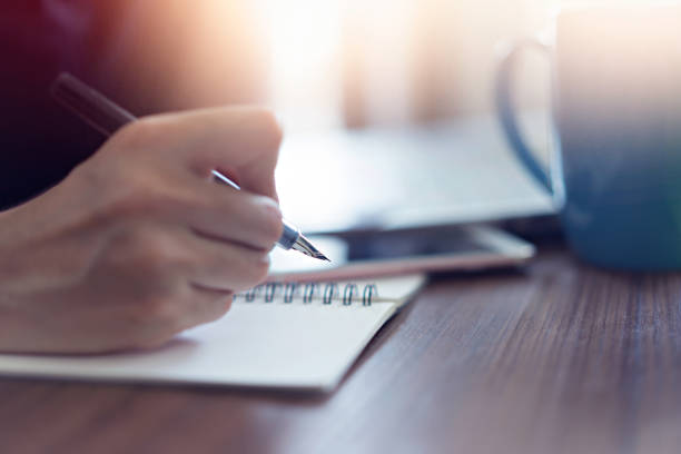 istock Hand using ink pen with notebook at office.  Business online concept 1097685596