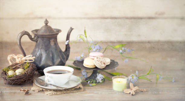 istock Vintage Easter Brunch with Tea and Macaroons on an Old Rustic White Wood Background 1097701650
