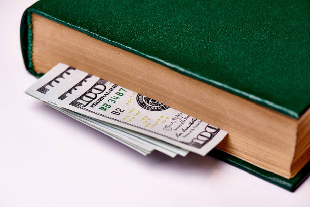 istock Bills worth one hundred US dollars in book on a white background macro. 1097729122