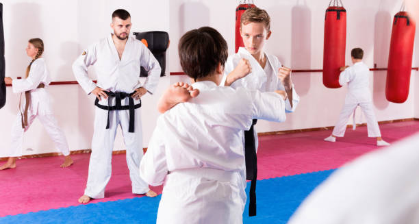 istock Kids in kimonos exercising techniques in pair during taekwondo class at gym 1097730802