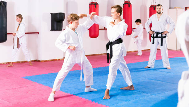 istock Kids in kimonos exercising techniques in pair during taekwondo class at gym 1097730844