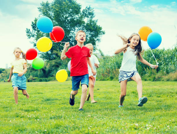 istock Four friendly glad kids running on green lawn 1097731214