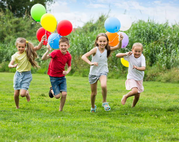 istock children running with air balloons in park 1097731236