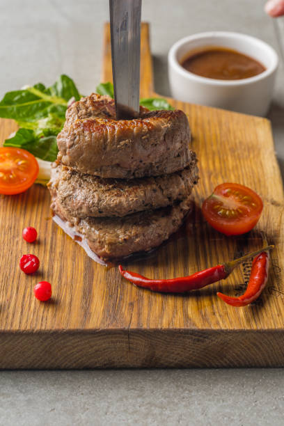 istock Three meatballs and a knife on a wooden board 1097733750