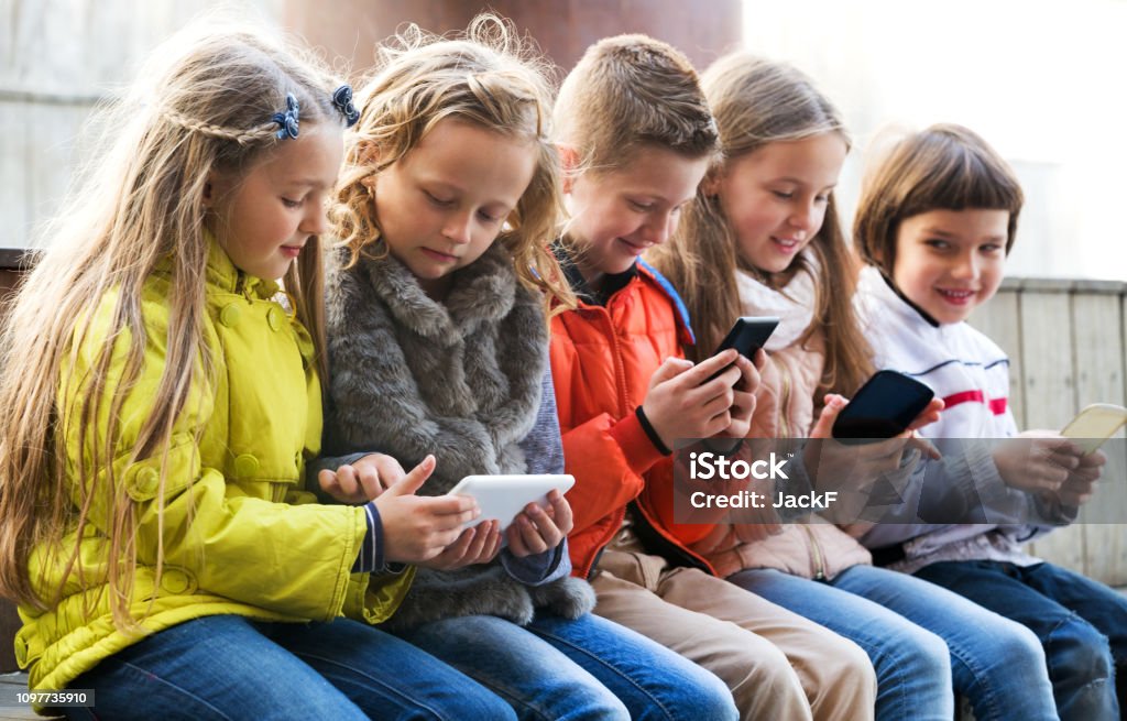 Niños jugando con los teléfonos móviles - Foto de stock de Niño libre de derechos