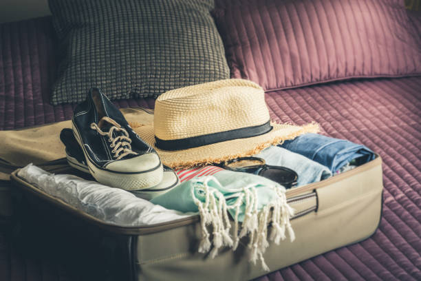 istock Open suitcase with female clothes for travel. Packing things. 1097739786