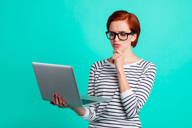 Clever pondering pensive deciding doubtful serious touching chin with short hairstyle bright business lady solving problem using network cowork holding notebook in hand isolated bright teal background