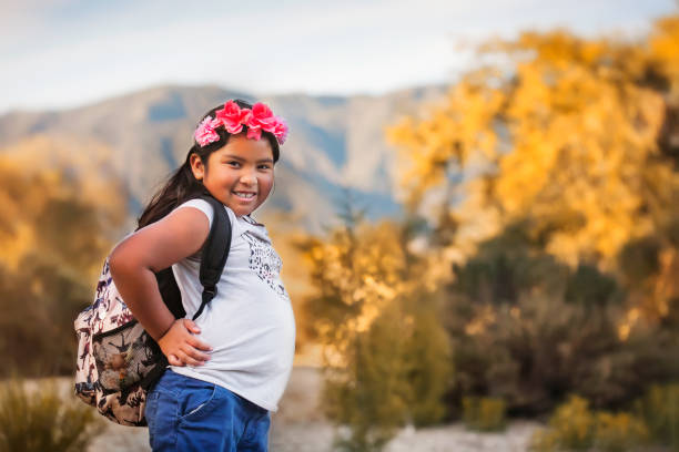 Elementary school female student wearing a backpack and smiling during a school field trip in southern california.