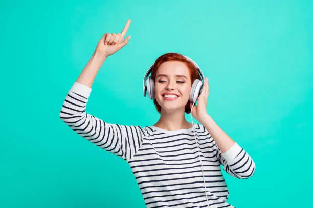 Photo of People good mood high spirits concept. Close up photo portrait of cheerful carefree careless glad nice beautiful millennial hearing familiar pop melody isolated on teal bright background