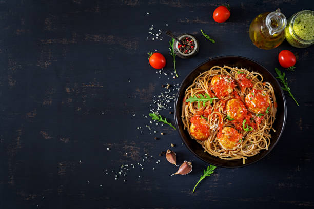 italian pasta. spaghetti with meatballs and parmesan cheese in black plate on dark rustic wood background.  dinner. top view. slow food concept - italian cuisine minced meat tomato herb imagens e fotografias de stock