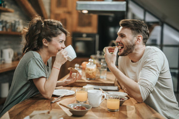 istock Young happy couple talking while eating breakfast in the morning. 1097745306