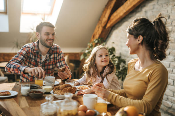 istock Young happy family communicating while having breakfast in dining room. 1097747554