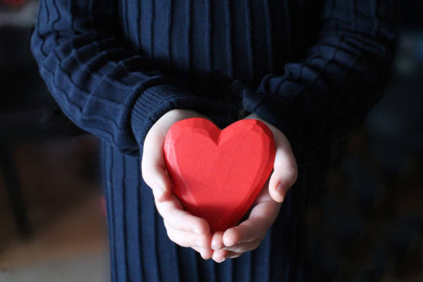 istock One girl holding red heart with both hand 1097747956