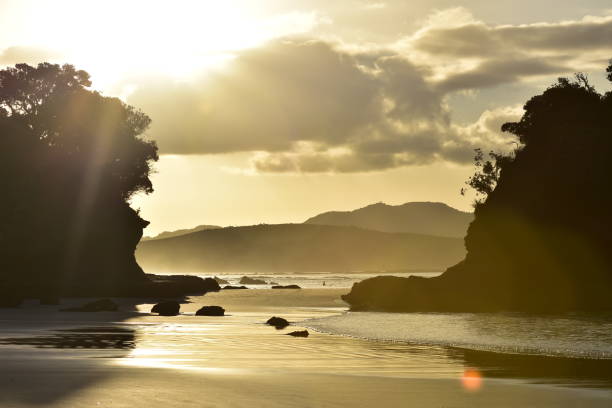 Oceanic beach with sand and rocks in back light