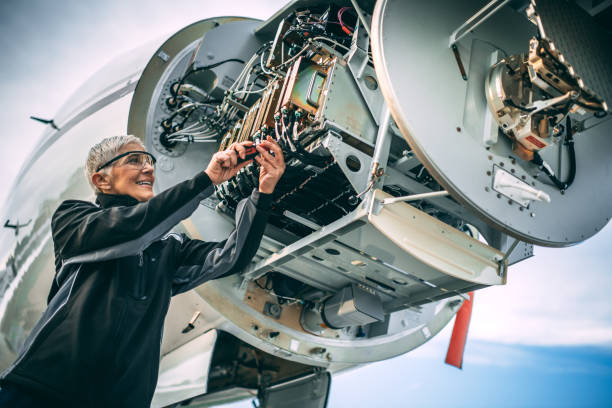 istock Elderly female engineer fixing a sensor and radar array in the nose cone of a small private airplane parked on an airport field 1097756824
