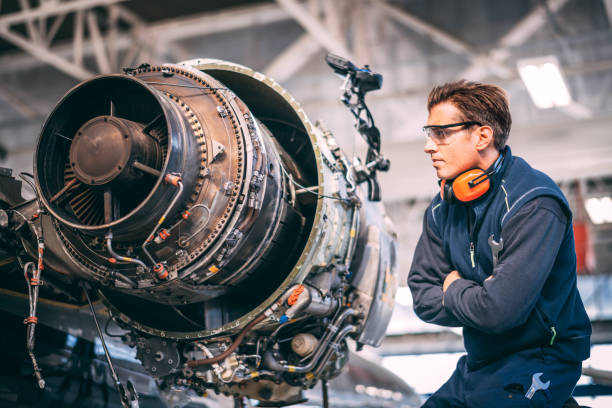 istock Aircraft mechanic looking at a small jet engine while holding a wrench in crossed arms 1097759544