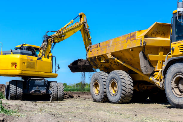 istock Excavator is loading a truck with ground on building site 1097761538