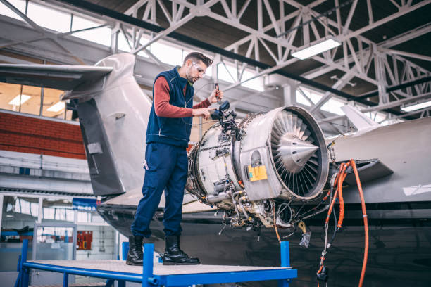 istock Airplane engineer standing on a work platform, unscrewing a piece of inner paneling of a small jet engine in an aircraft hangar 1097762420