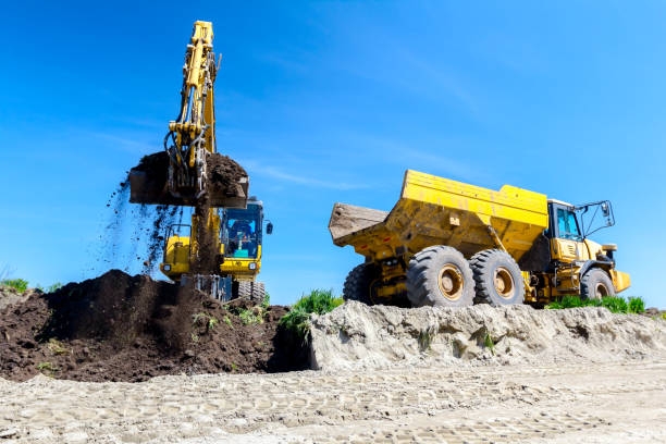 istock Excavator is loading a truck with ground on building site 1097762804