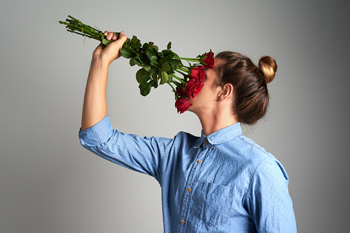 Studio shot of an unrecognizable man holding flowers against a grey background