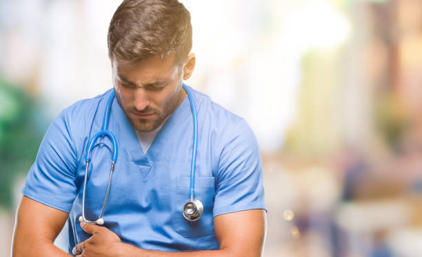 istock Young handsome doctor surgeon man over isolated background with hand on stomach because nausea, painful disease feeling unwell. Ache concept. 1097765988