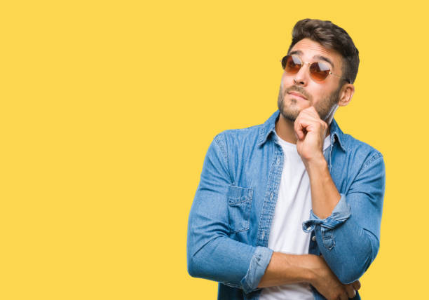 istock Young handsome man wearing sunglasses over isolated background with hand on chin thinking about question, pensive expression. Smiling with thoughtful face. Doubt concept. 1097766228