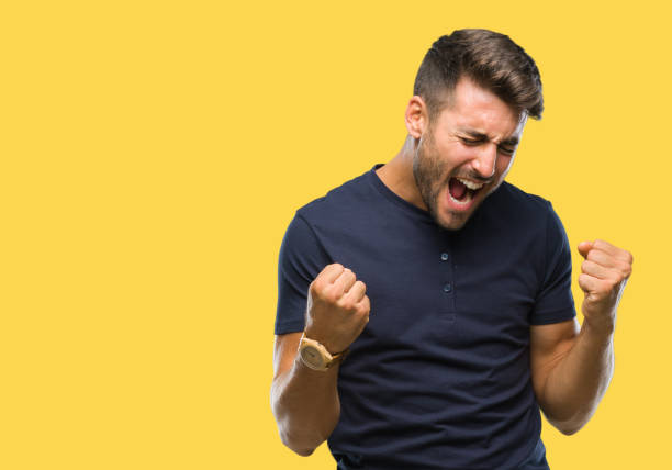 Young handsome man over isolated background very happy and excited doing winner gesture with arms raised, smiling and screaming for success. Celebration concept.