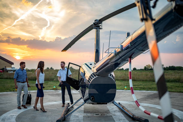 istock Businesspeople approaching helicopter with pilot standing by 1097766410