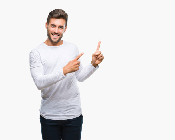 istock Young handsome man over isolated background smiling and looking at the camera pointing with two hands and fingers to the side. 1097771588