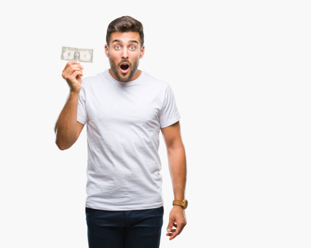 istock Young handsome man holding dollars over isolated background scared in shock with a surprise face, afraid and excited with fear expression 1097772154