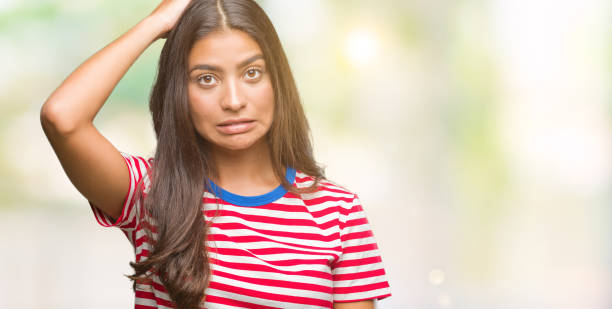Young beautiful arab woman over isolated background confuse and wonder about question. Uncertain with doubt, thinking with hand on head. Pensive concept.
