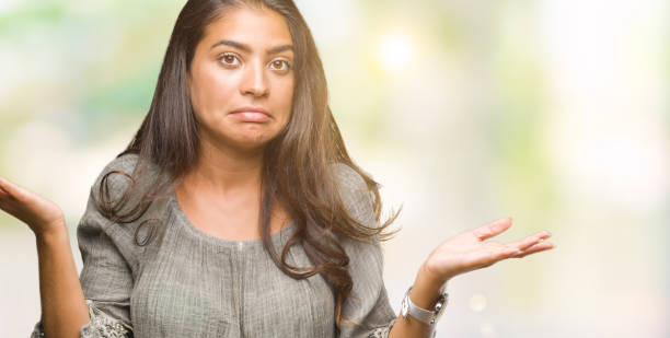istock Young beautiful arab woman over isolated background clueless and confused expression with arms and hands raised. Doubt concept. 1097773066