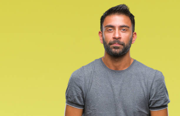 istock Adult hispanic man over isolated background with serious expression on face. Simple and natural looking at the camera. 1097775964