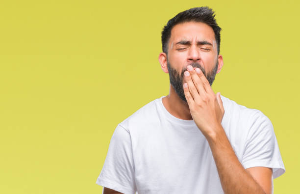 Adult hispanic man over isolated background bored yawning tired covering mouth with hand. Restless and sleepiness. Adult hispanic man over isolated background bored yawning tired covering mouth with hand. Restless and sleepiness. yawning stock pictures, royalty-free photos & images