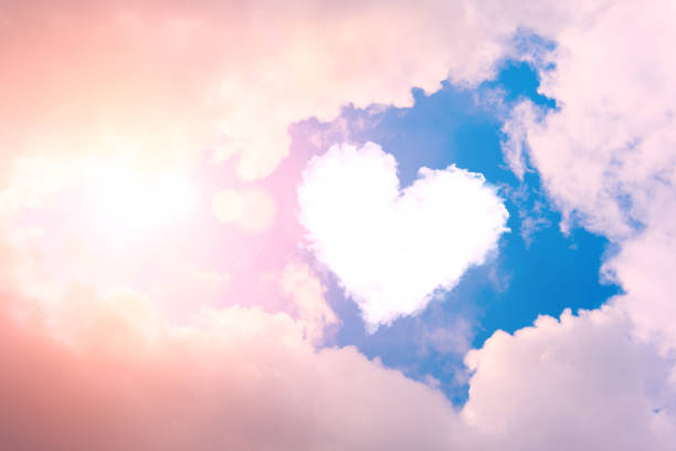 cuore nuvoloso nel cielo tra le nuvole e il sole. - amore foto e immagini stock