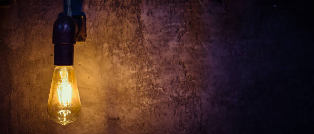 istock Led lamp shines yellow light against a gray wall 1097781356