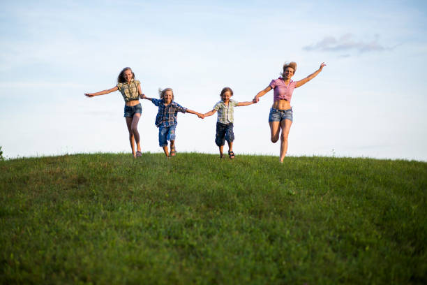 istock Mother and children running in nature 1097783274