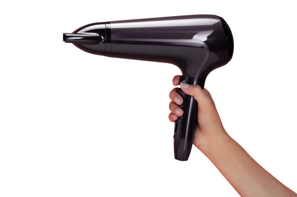 женская рука холдинг фен изолированы на белом - hair dryer single object plastic black стоковые фото и изображения