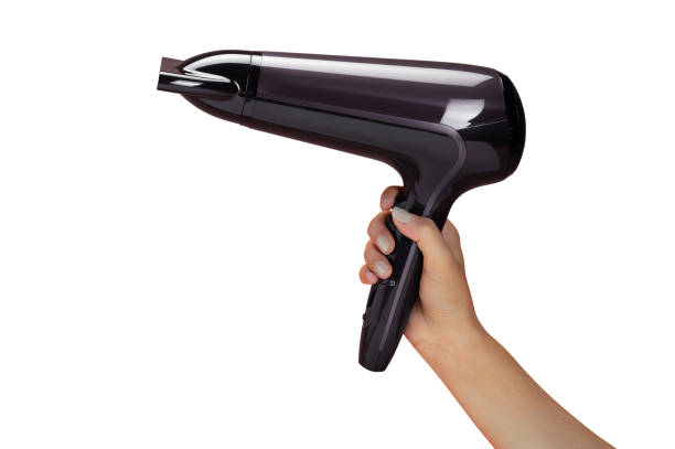 женская рука холд�инг фен изолированы на белом - hair dryer single object plastic black стоковые фото и изображения