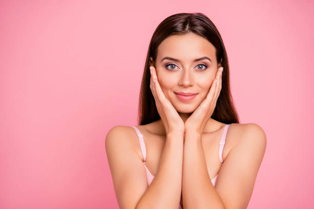 retrato de hermosa lindo suave tratando de fregar efecto tocar piel con brazos de cerca a su niña lleva sujetador rosa pálido aislado sobre fondo rosa - tan skin fotografías e imágenes de stock