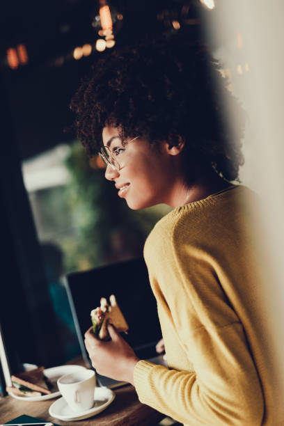 istock Young woman sitting inside cafe and heaving lunch 1097790972