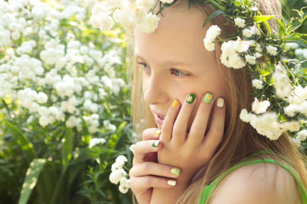 istock Children's multi-colored manicure on nails with a pattern of daisies 1097794590