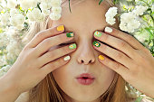 Children's multi-colored manicure on nails with a pattern of daisies