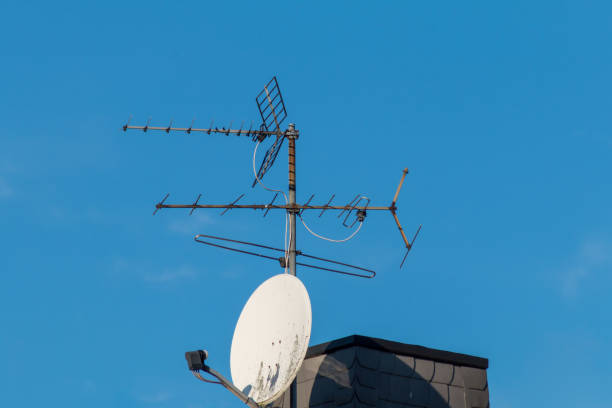 old tv antennas and satellite dish on the roof - antena de televisão imagens e fotografias de stock